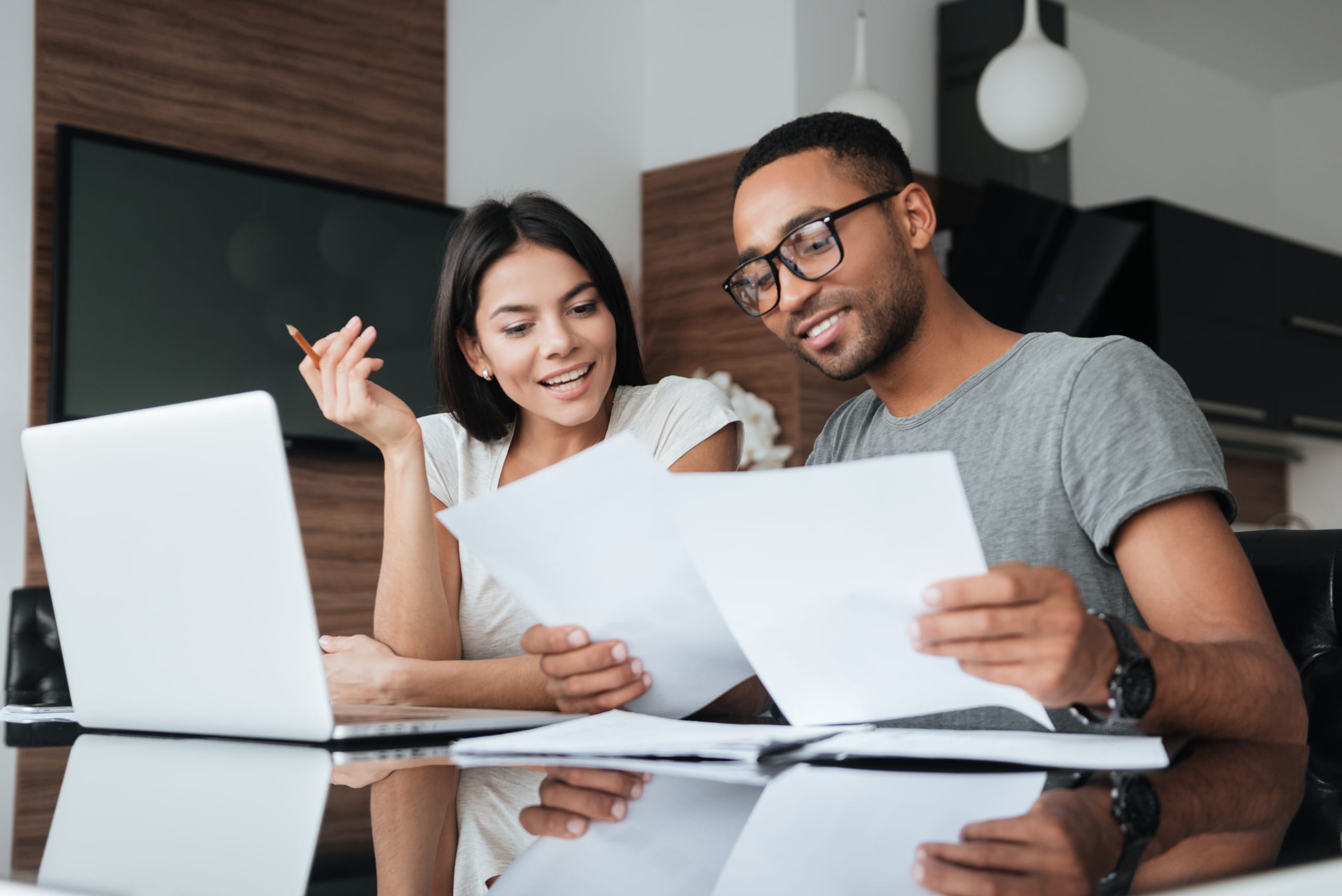 Photo of two people looking at their taxes on the computer and in a notebook